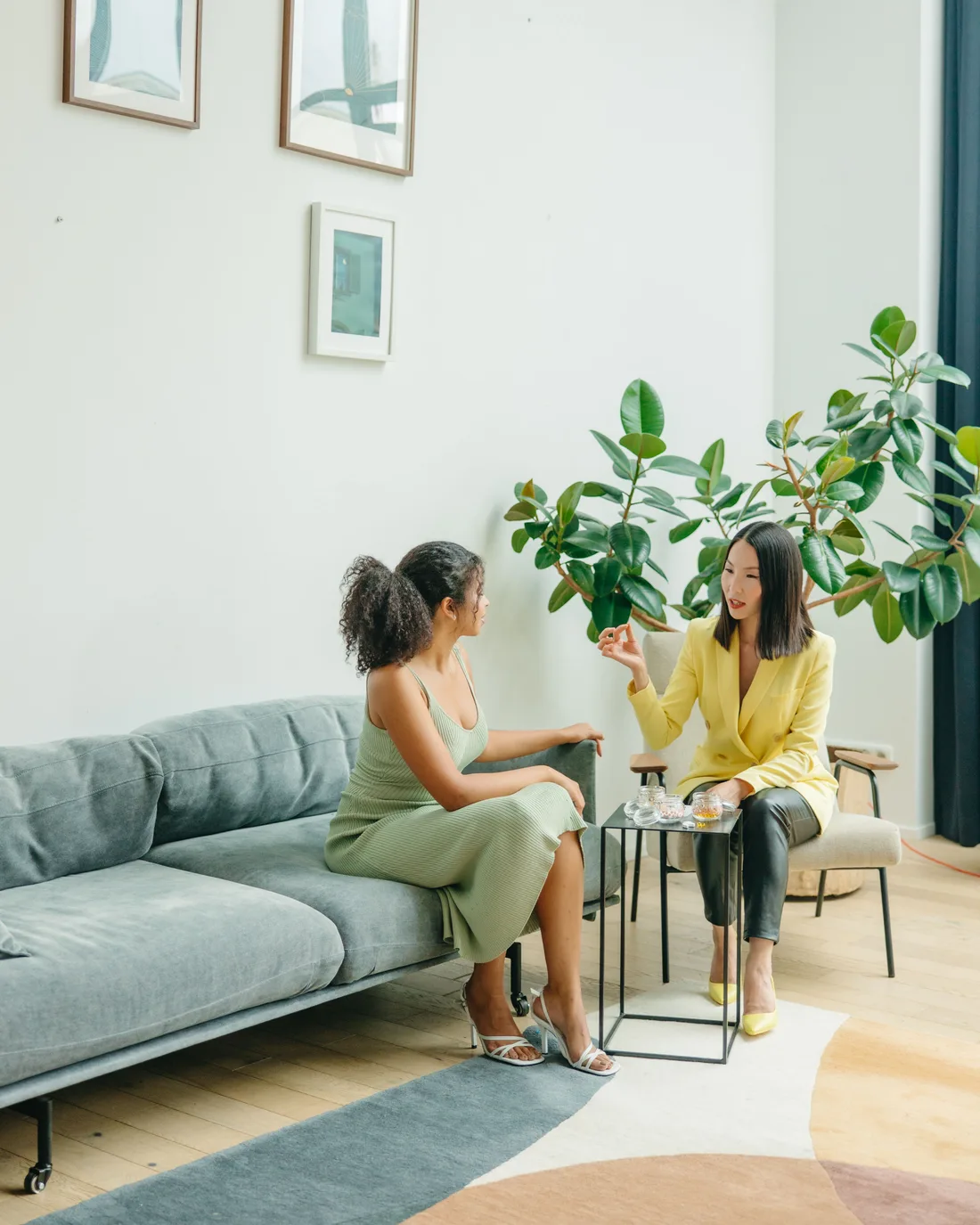 Séance de coaching : deux femmes en conversation, assises dans un salon lumineux et apaisant